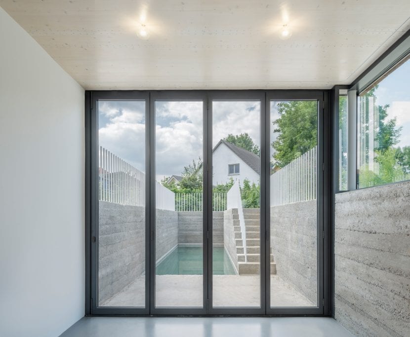 Das untere Schlafzimmer hat direkten Zugang zum langgestreckten Pool im Garten. (Foto: Gui Rebelo / rundzwei Architekten)