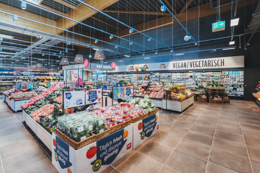 Der Frischebereich im neuen REWE-Markt, darüber das Tragwerk aus Holzleimbindern mit Spannweiten bis zu 27 Metern (Foto: Christoph Große)