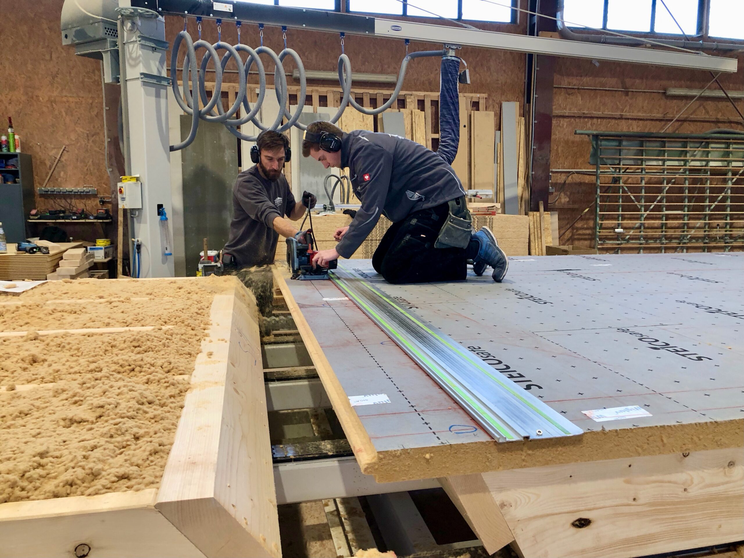 Mit einer elektrischen Säge werden die Unterdeckplatten exakt auf die Maße des Holzbaurahmens zugeschnitten (Foto: Eric Sturm)