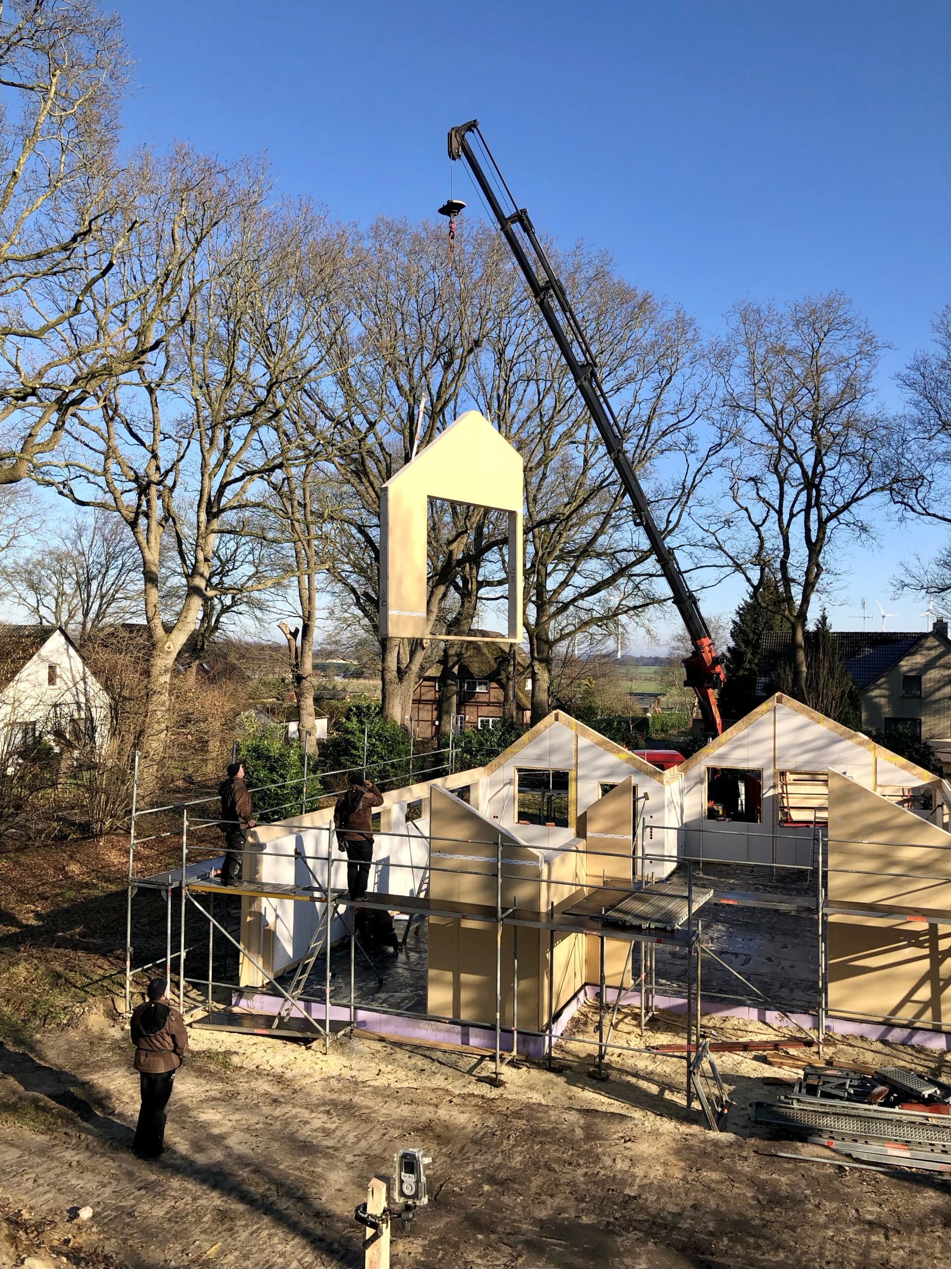 Holzrahmen-Tetris: Milimetergenau werden die Wand- und Dachelemente per Fernsteuerung platziert und heruntergelassen (Foto: Eric Sturm)