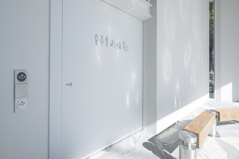 Piktogramme zeigen die vorhandene Ausstattung der jeweiligen Toilettenräume. Sie sind an der automatischen Schiebetür angebracht. (Standort: Hatagaya, Designer: Miles Pennington / DLX Design Lab, Foto: The Nippon Foundation / TOTO Ltd.)