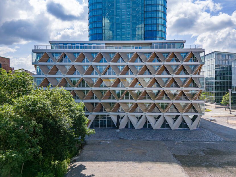 Die rautenförmige Gestaltung der Fassade erfüllt mehrere Funktionen: Sie verbindet Tragwerk, Sonnenschutz und Loggien (Quelle: HPP Architekten GmbH, Foto: © Ralph Richter)